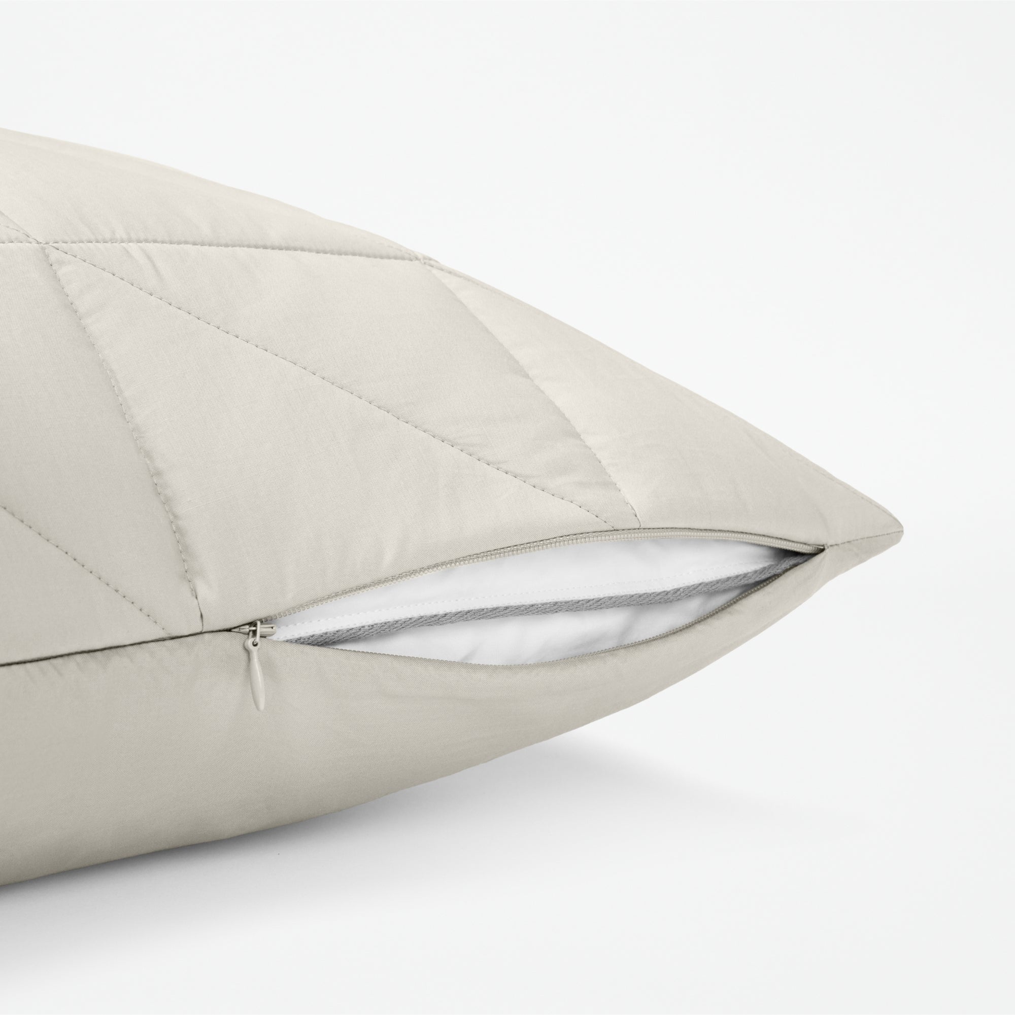 The Tuft and Needle Classic Percale Body Pillow Cover, showing a zipper slightly open to the pillow inside || color: Sand