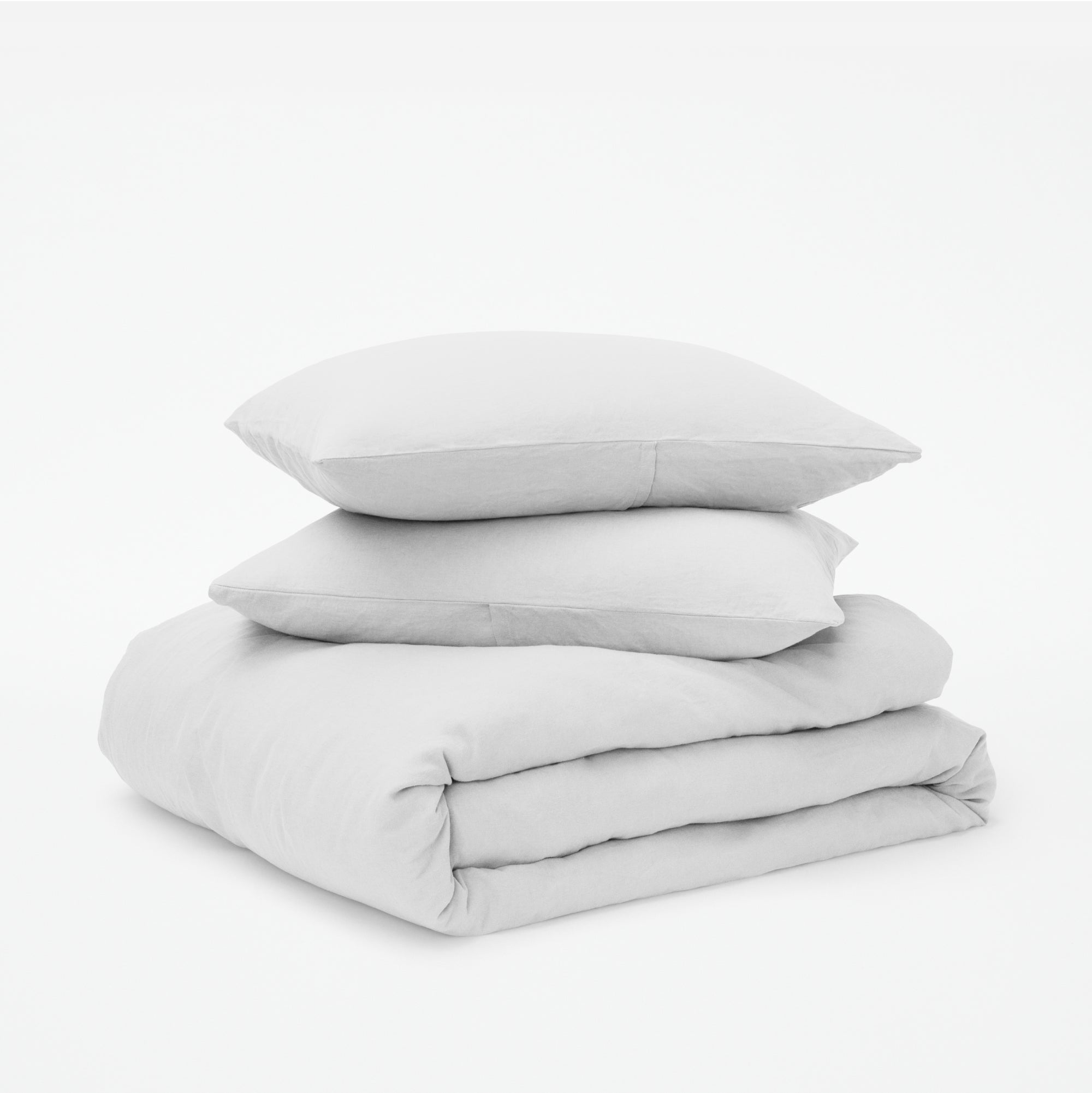 The Tuft and Needle Linen-Cotton Blend Duvet Set, 2 pillows stacked on 1 duvet covered blanket || color: Cloud