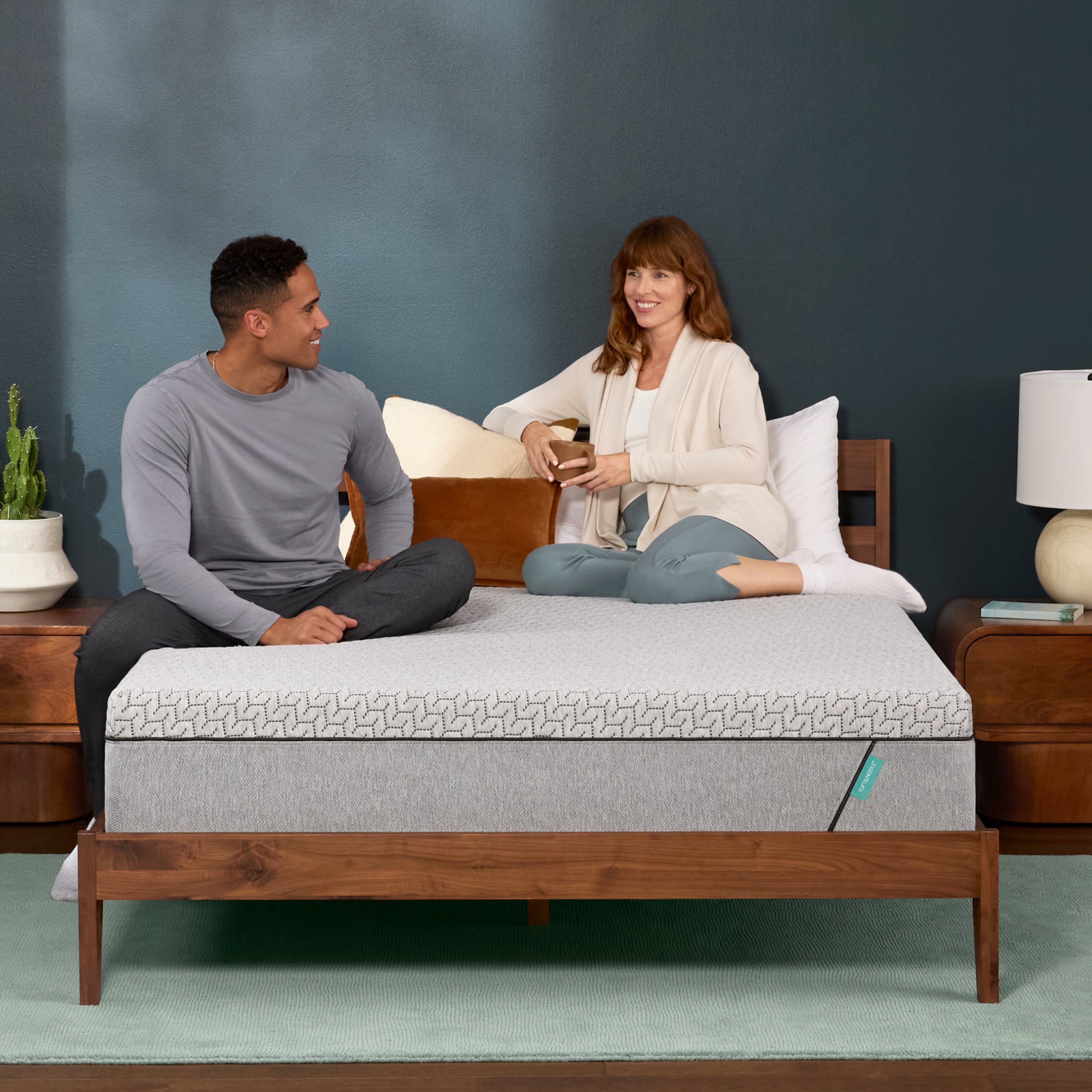 Couple relaxes on a mint mattress.