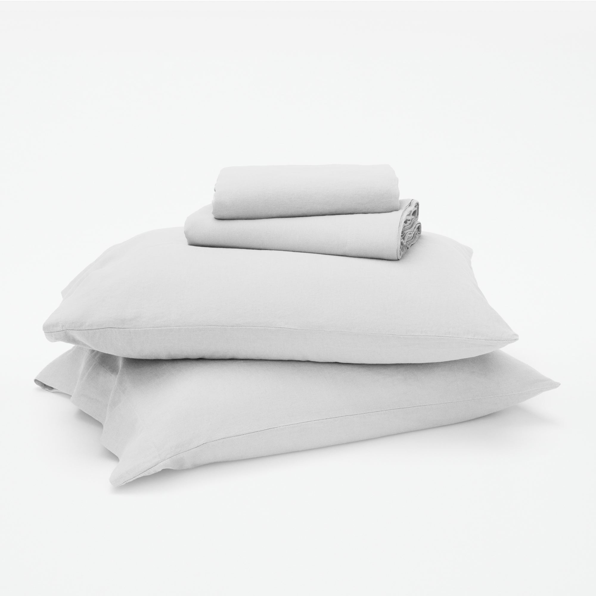 The Tuft and Needle Linen-Cotton Blend Sheet Set, 2 sheets stacked on 2 pillows || color: Cloud
