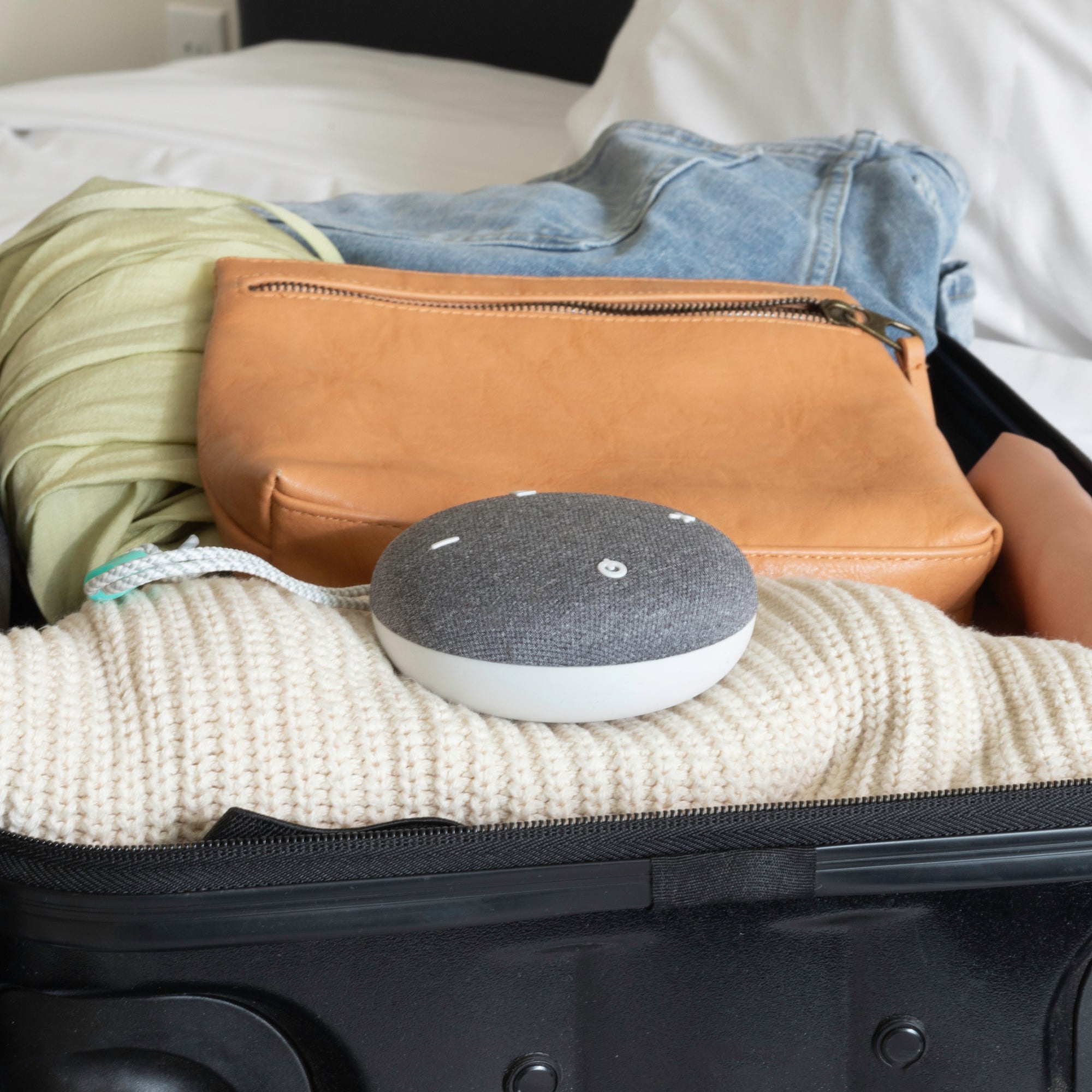 Snooz Go Travel White Noise Machine in a carry on bag full of luggage showing how compact it is.