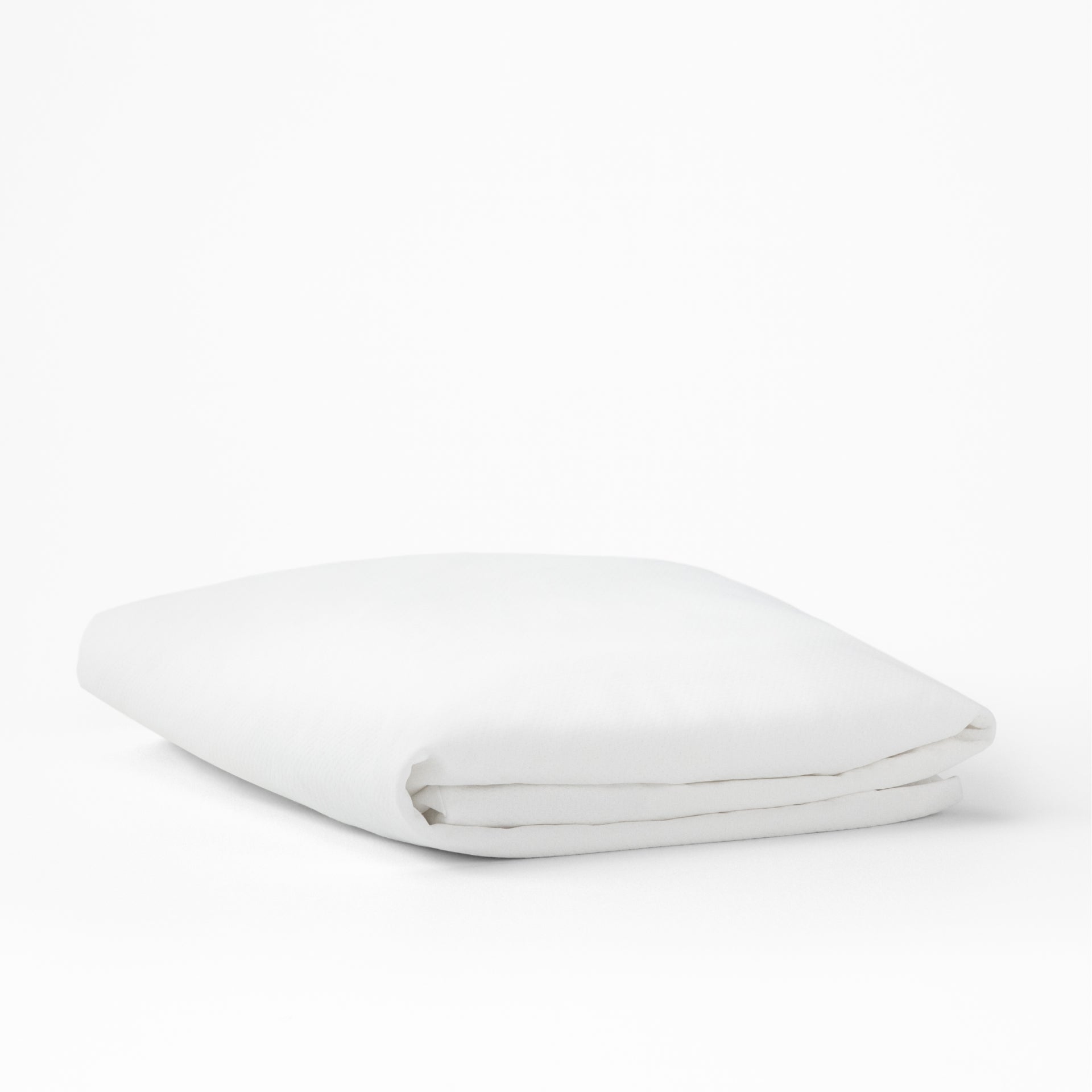 The Tuft and Needle Mattress Protector folded on a white background