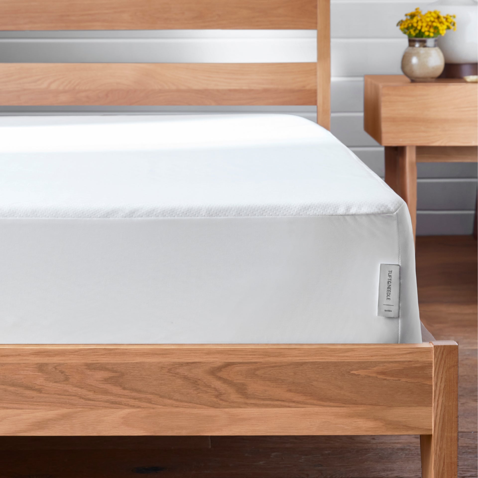 The Tuft and Needle Mattress Protector on a mattress in a bedroom